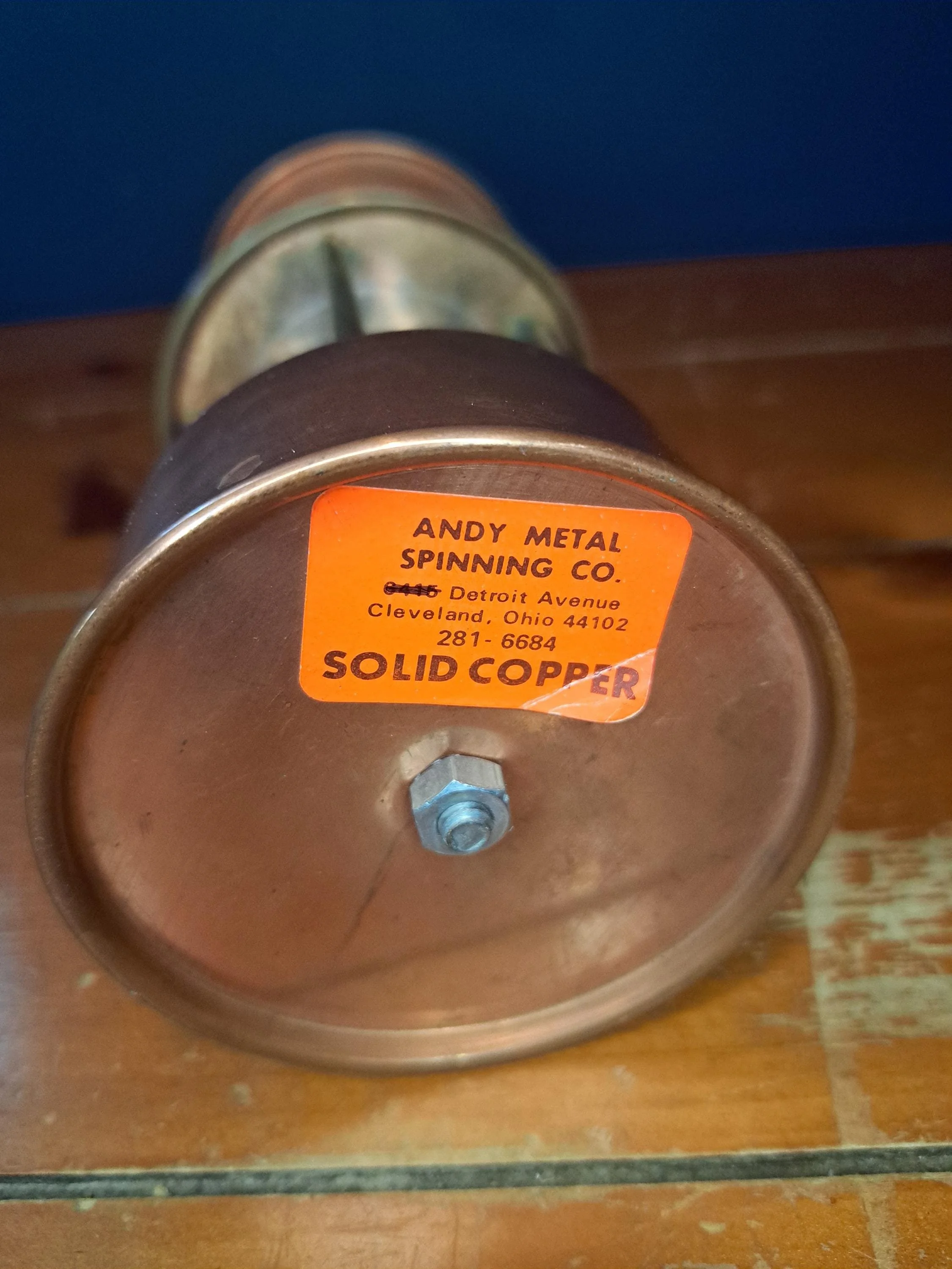 Close-up of solid copper maker label on a vintage lantern.