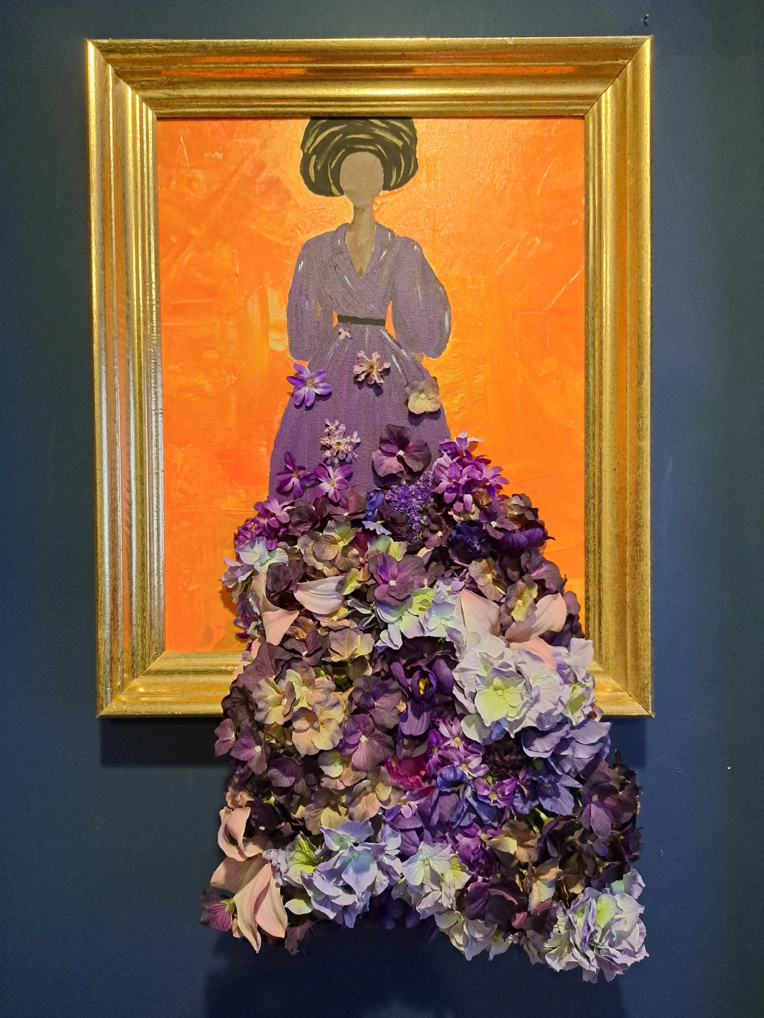 Framed mixed-media floral figure wall art with purple flowers.